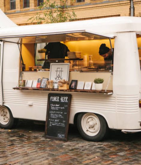 Berlin, October 1, 2017: White cozy small mini bus food market with snacks and coffee and two sellers